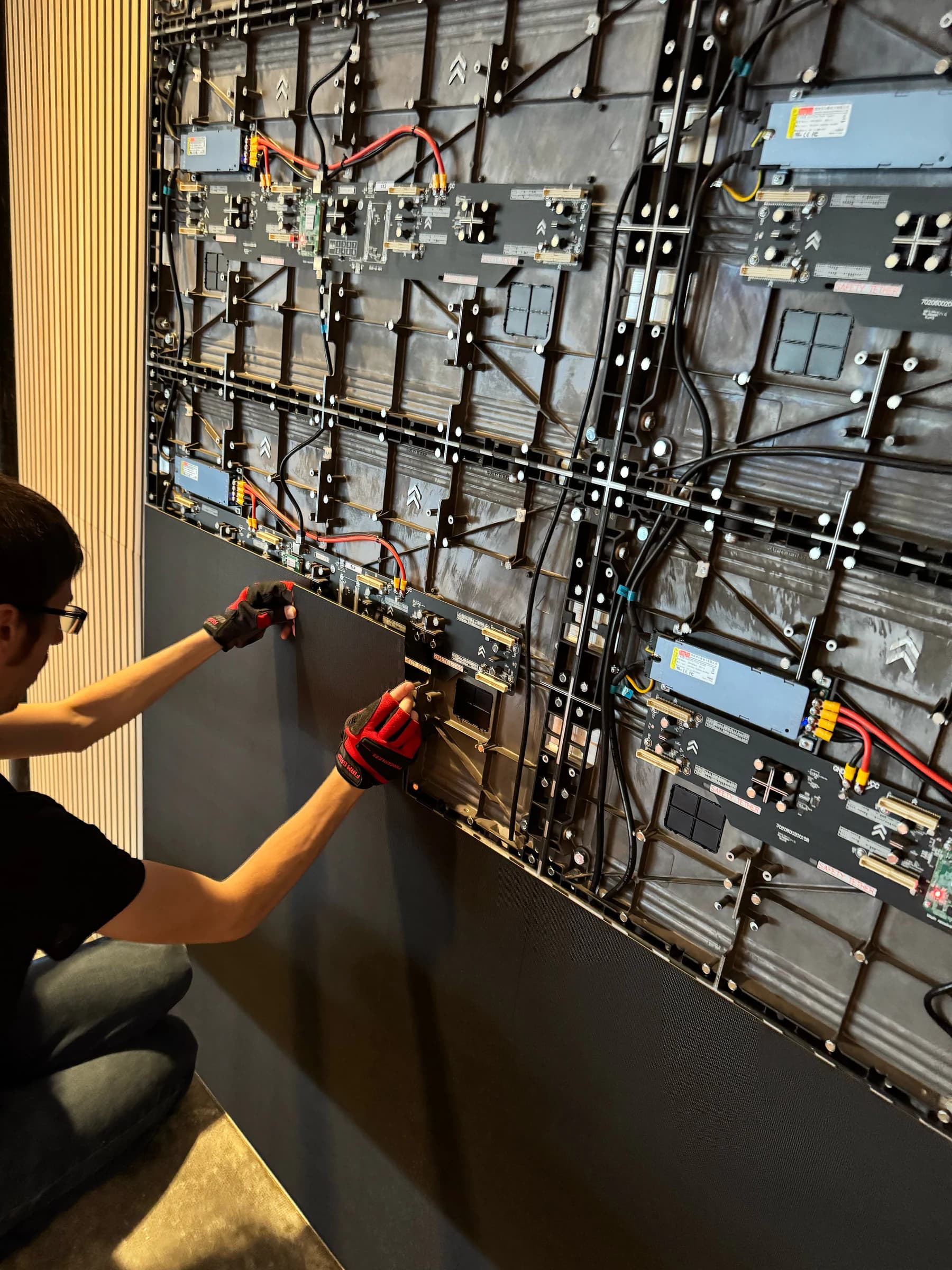 Qohr installer seating an LED module into the Mannahouse cabinet grid