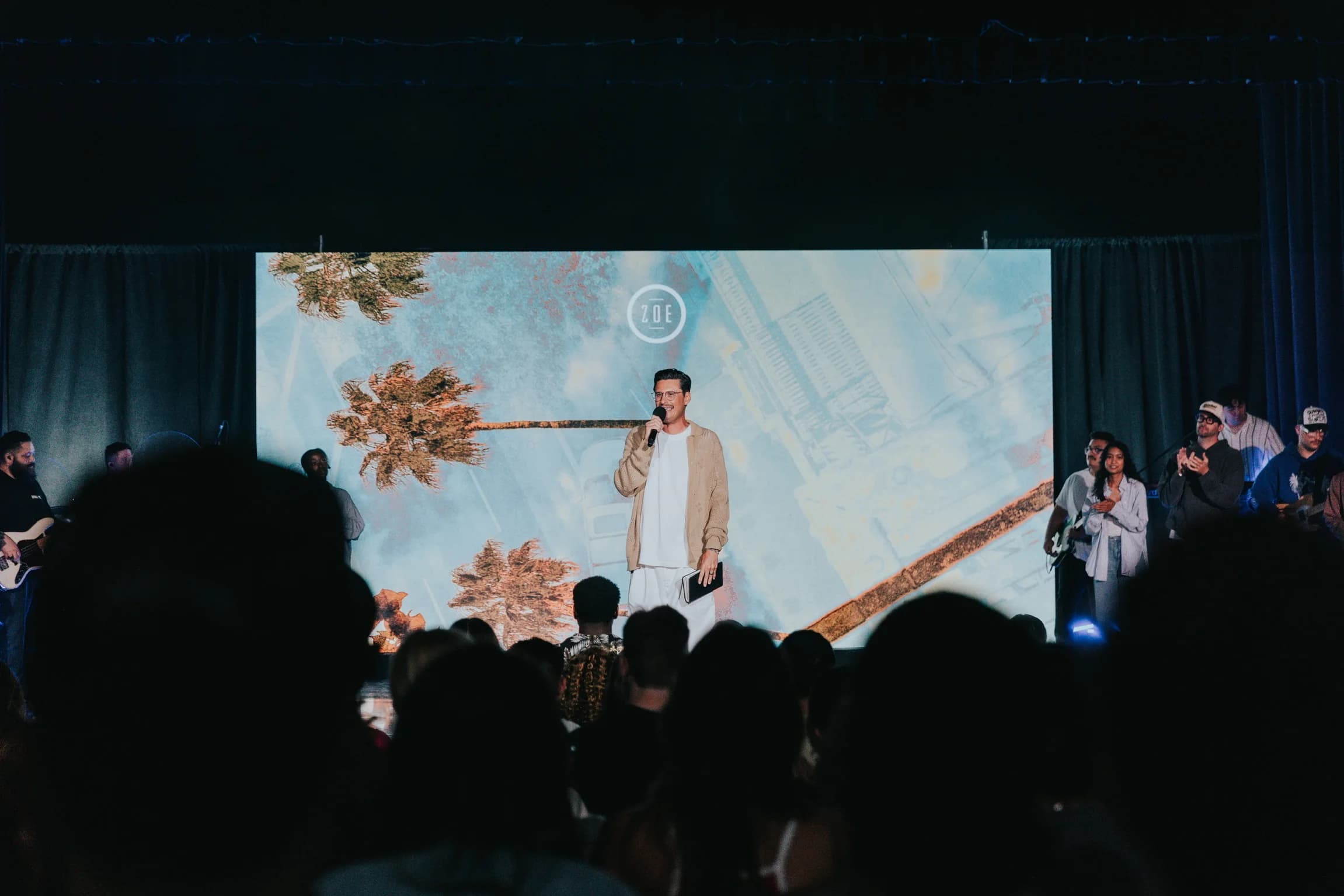 Speaker addressing the congregation in front of the portable LED wall at Zoe Church South Bay
